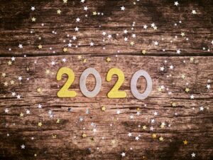 2020 on a wooden background surrounded by confetti