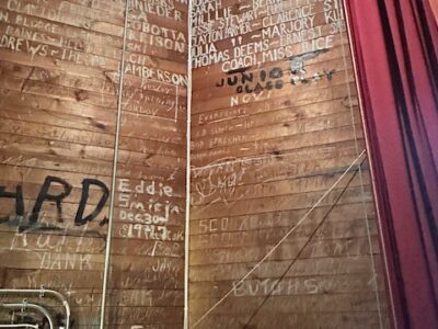 Cast member signatures on a backstage wall
