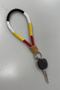 Beaded wristlet for keys made by students. Its end is wrapped in buckskin.
