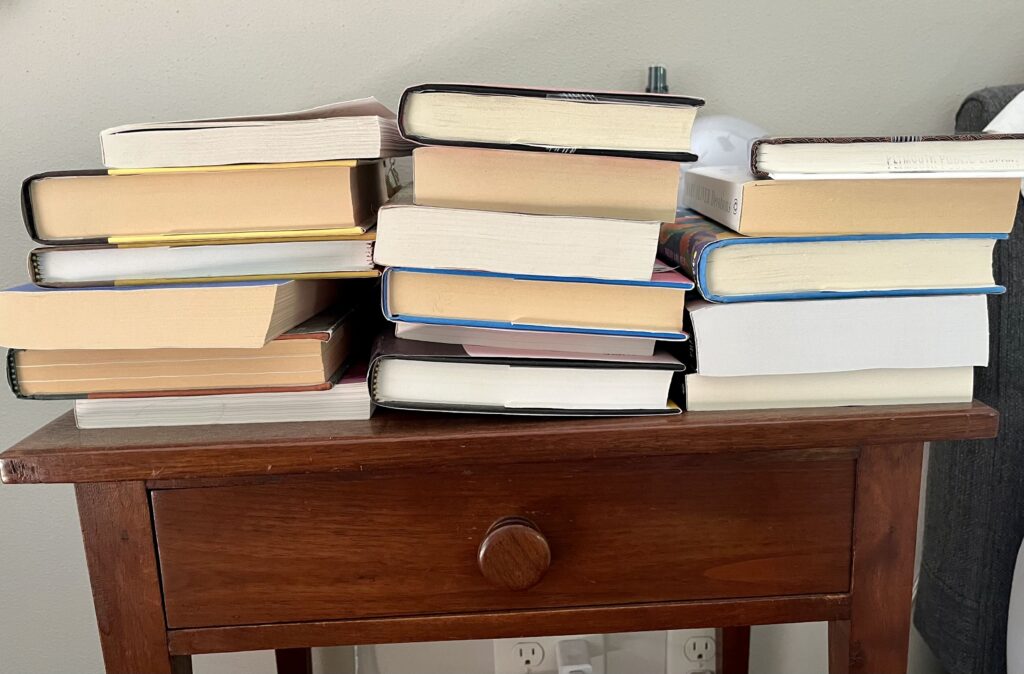 Jen's nightstand stacked with books